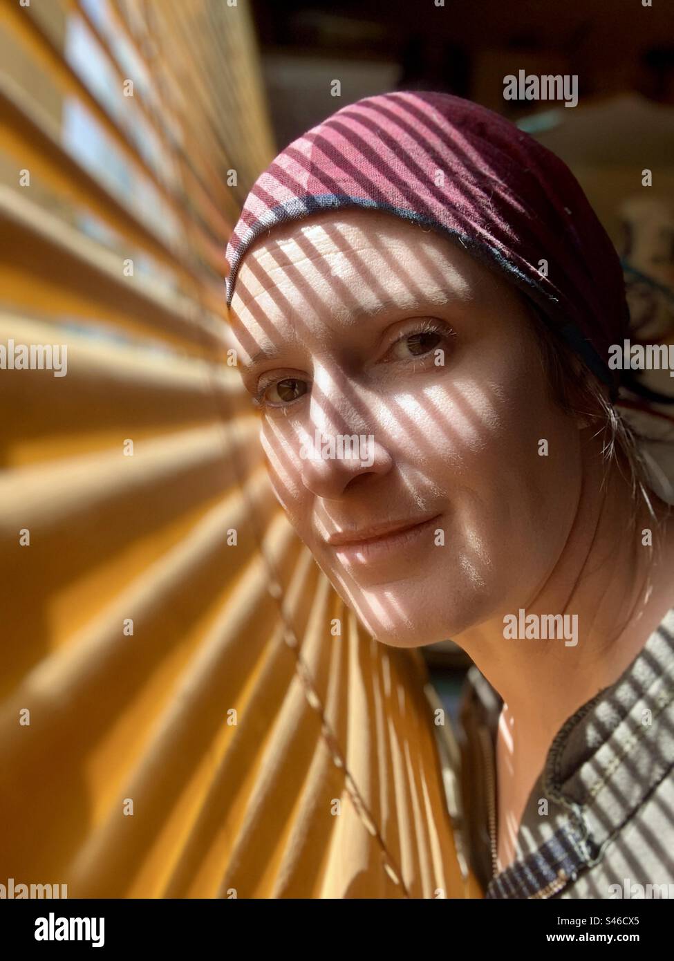Frau im Schatten der Jalousien Stockfoto