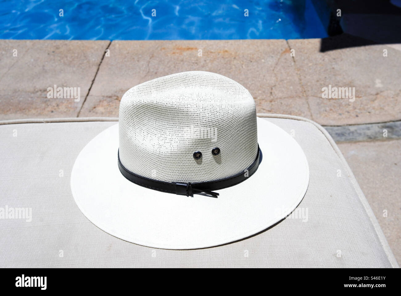 Hut auf dem Liegestuhl in der Nähe des Pools im Urlaub - Smartphone-aufgenommenes Stockfoto