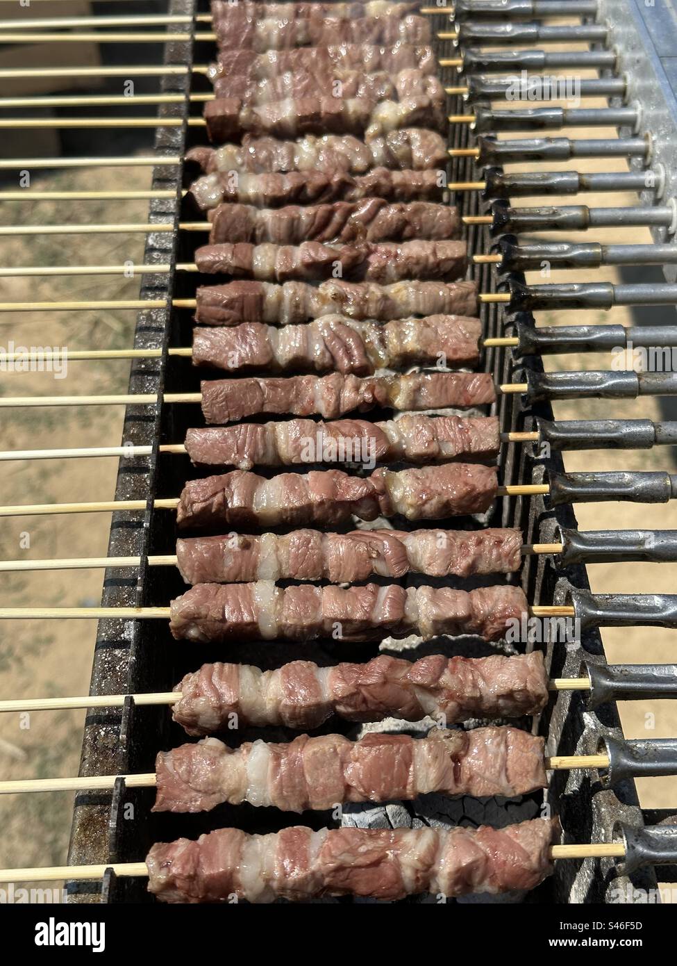 Arrosticini, traditionelle Gerichte mit gegrilltem Fleisch, typisch für Molisana und die abruzzesische Küche, hergestellt aus Hammel- oder Lammfleisch, in Stücke geschnitten und von einem Spieß durchbohrt Stockfoto
