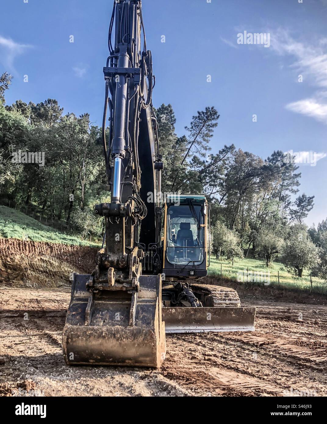 Ein Bagger in Ruhe in einem frisch gegrabenen Bereich - Smartphone-aufgenommenes Stockfoto