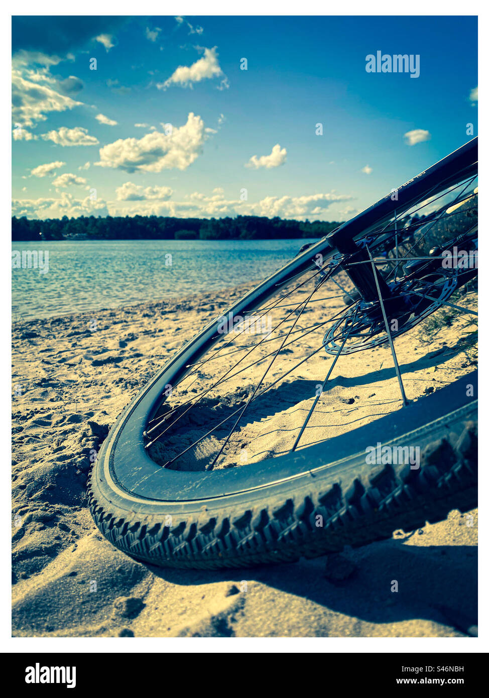 Ein Kiesrad liegt im Sand neben einem Süßwassersee im ländlichen Norfolk England Stockfoto