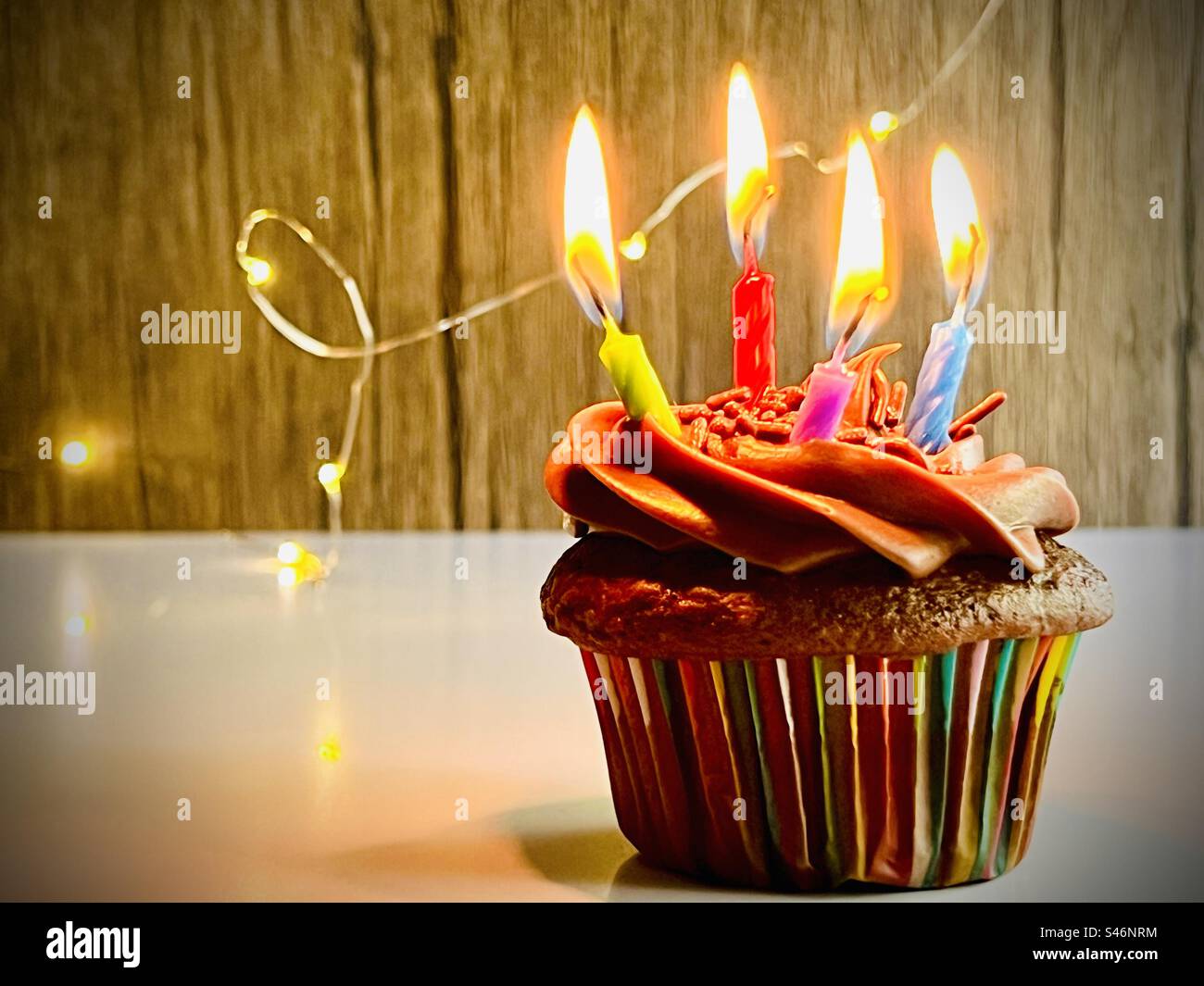 Schokoladen-Cupcake mit vier Geburtstagskerzen Stockfoto