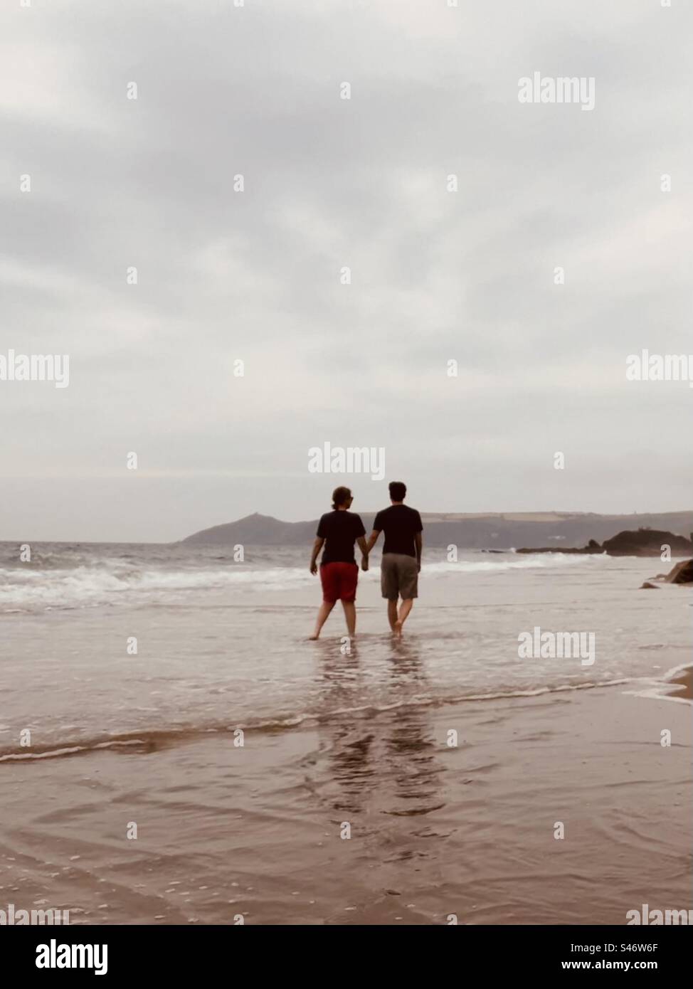 Glückliches Paar bei einem romantischen Strandspaziergang Stockfoto