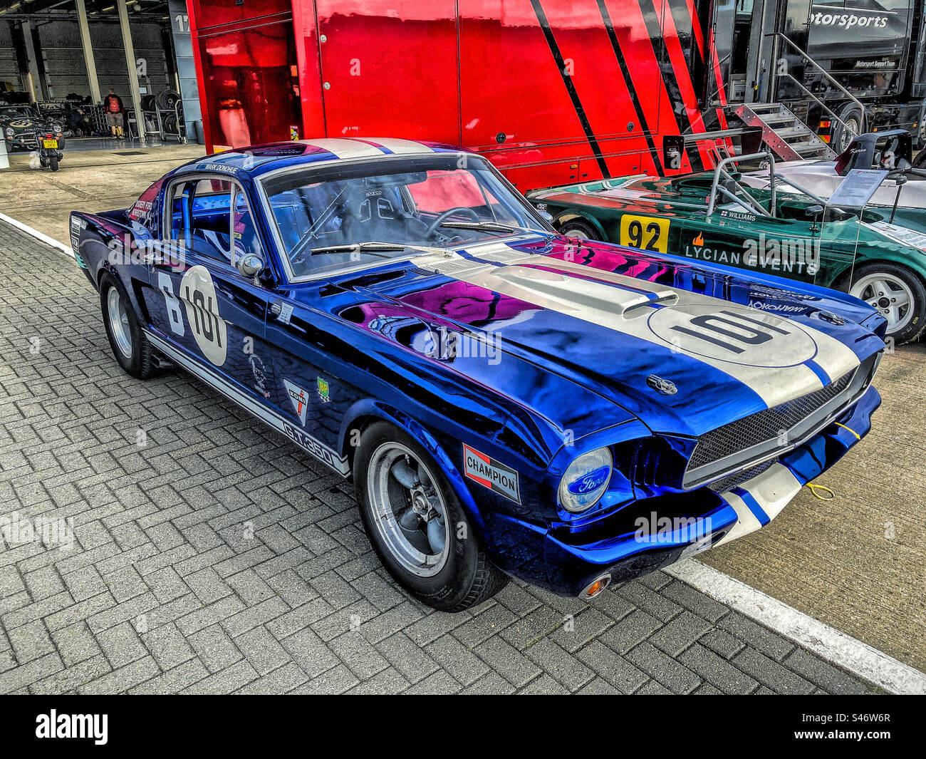 Das Rennen bereitete den 1960er-Klassiker Ford Mustang im internationalen Fahrerlager während des Silverstone Festivals 2023 vor - Smartphone-aufgenommenes Stockfoto