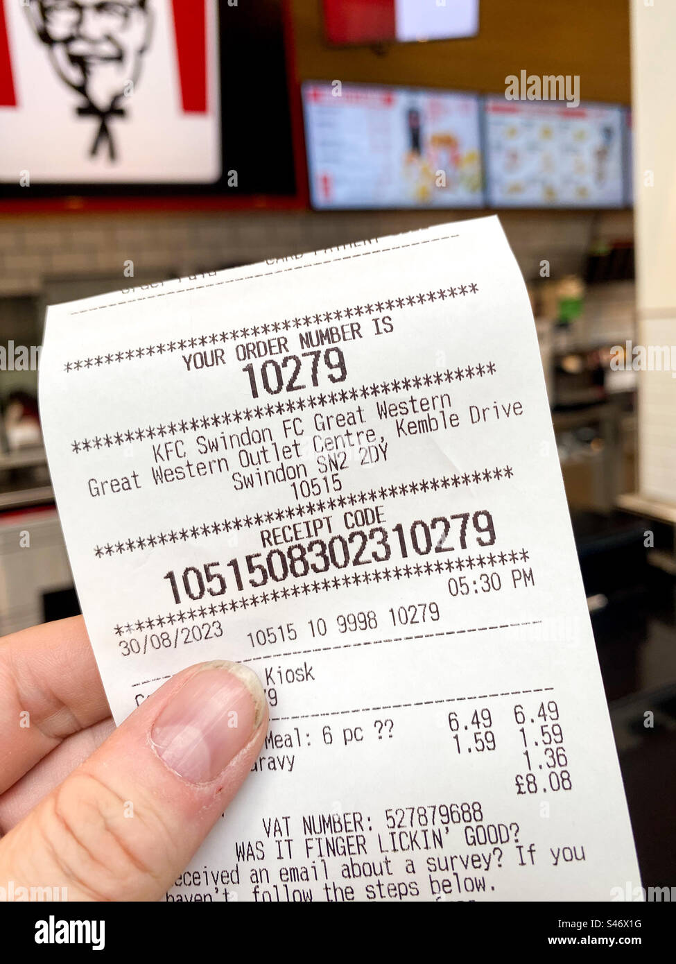 Eine Quittung von einem Selbstbestellgerät in einem KFC-Fast-Food-Restaurant mit einer Bestellnummer, die zur Abholung der Speisen verwendet wird. - Smartphone-aufgenommenes Stockfoto