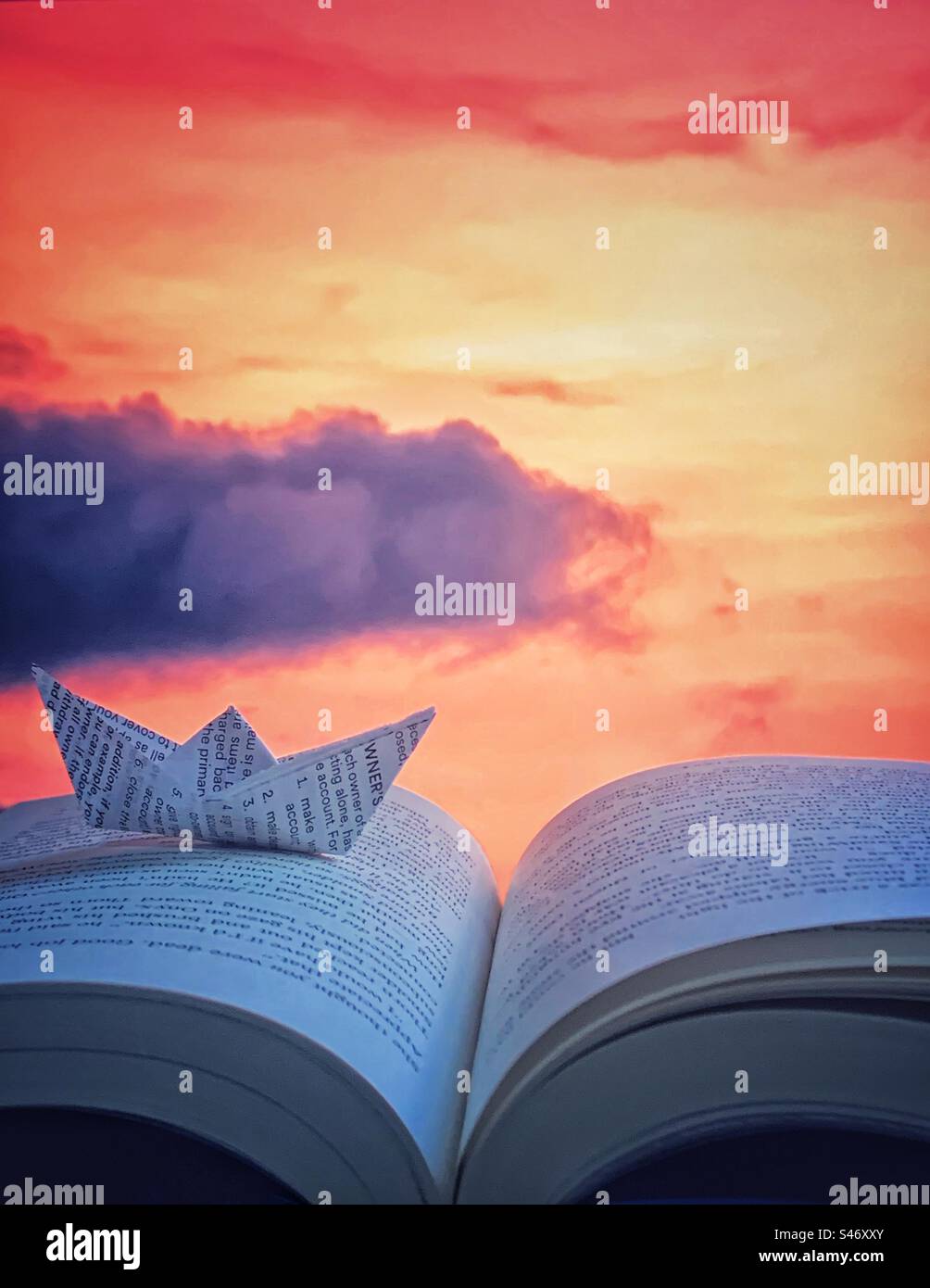 Segeln durch den Sonnenuntergang auf einem Meer aus Büchern Stockfoto