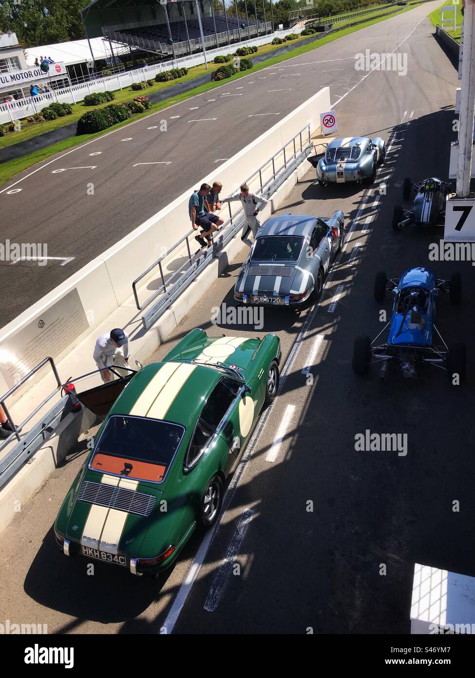Die 1960er Porsche 911er reihten sich in der Pit Lane auf der Goodwood Rennstrecke Chichester UK ein - Smartphone-aufgenommenes Stockfoto