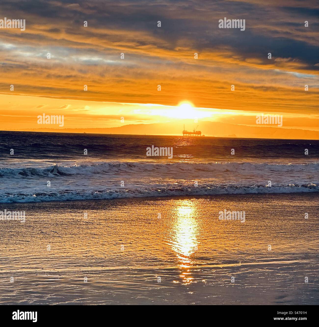 Sonnenuntergang über der Halbinsel Palms Verdes und der Offshore-Ölbohrplattform, von Sunset Beach (Huntington Beach, Kalifornien) aus gesehen. Stockfoto