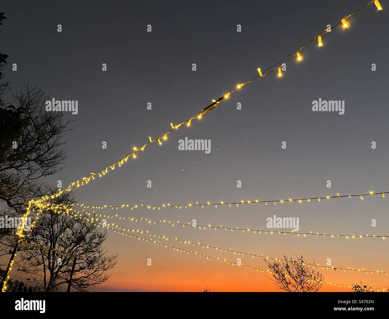 Party-Lichter im Freien bei Sonnenuntergang Stockfoto