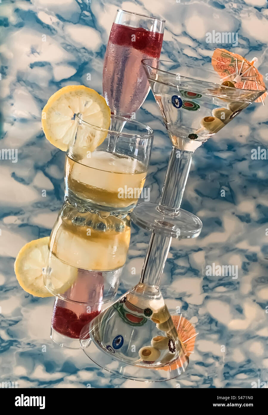 Alkoholische Getränke auf reflektierender Oberfläche mit gemustertem Hintergrund Stockfoto