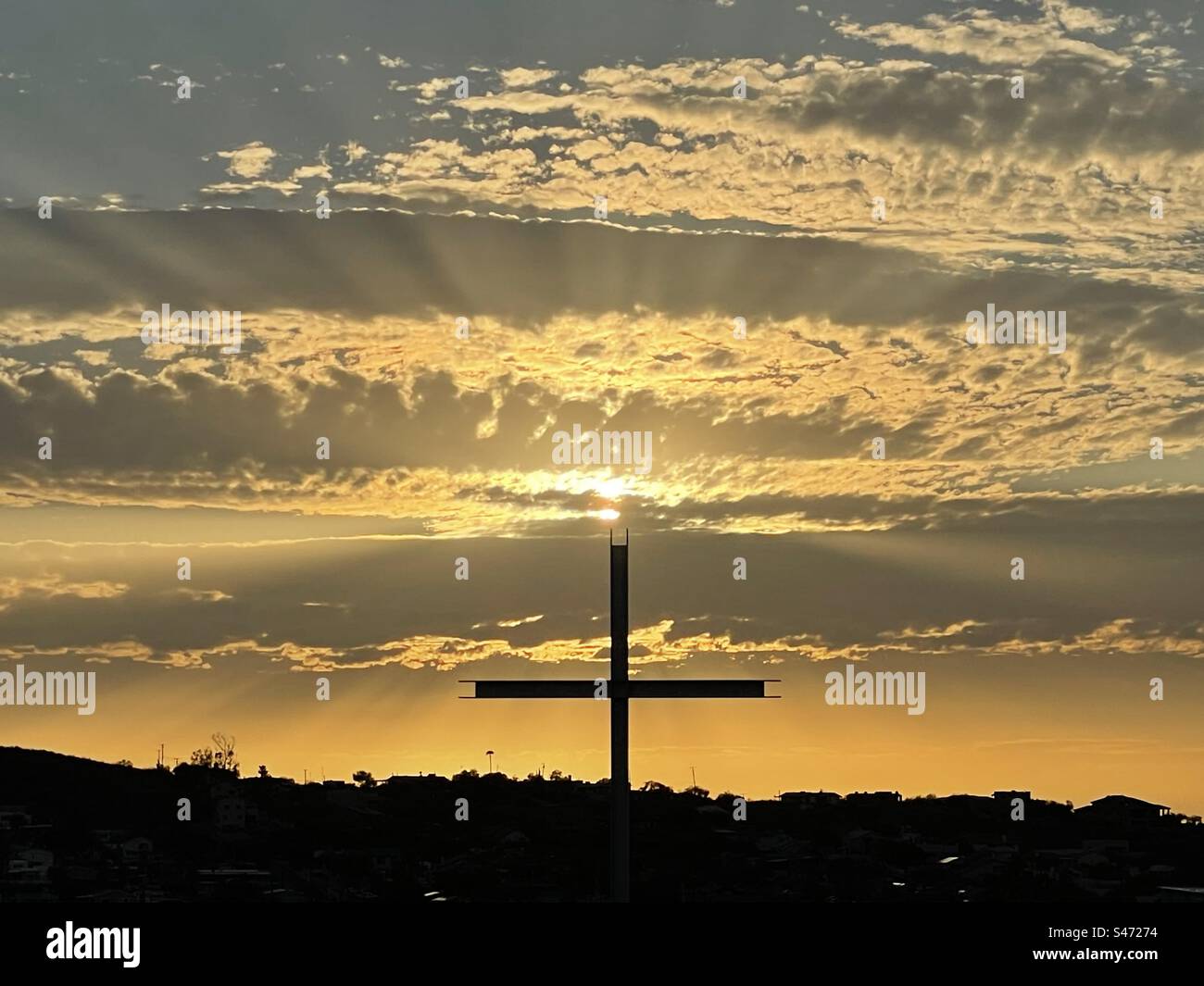 Goldener Sonnenuntergang über dem Kreuz, Lichtstrahlen, leuchtende Wolken, North Phoenix Stockfoto