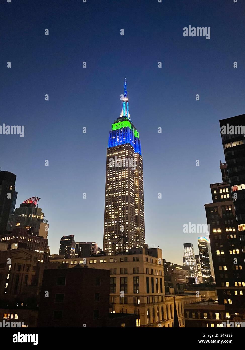 Blau-weiß-grüne Tower Lights auf dem Empire State Building zu Ehren des 30-jährigen Jubiläums von Extra TV am 6. September 2023 in New York City, USA Stockfoto