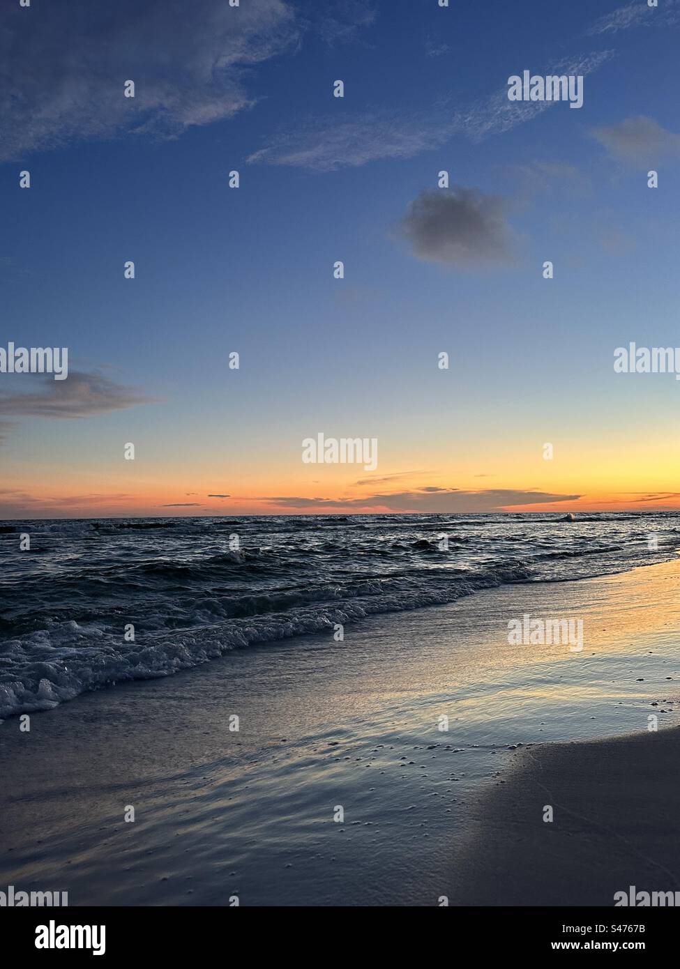 Farbenprächtiger Sonnenuntergang über dem Golf von Mexiko Florida Emerald Coast mit Reflexionen auf den Sand Stockfoto