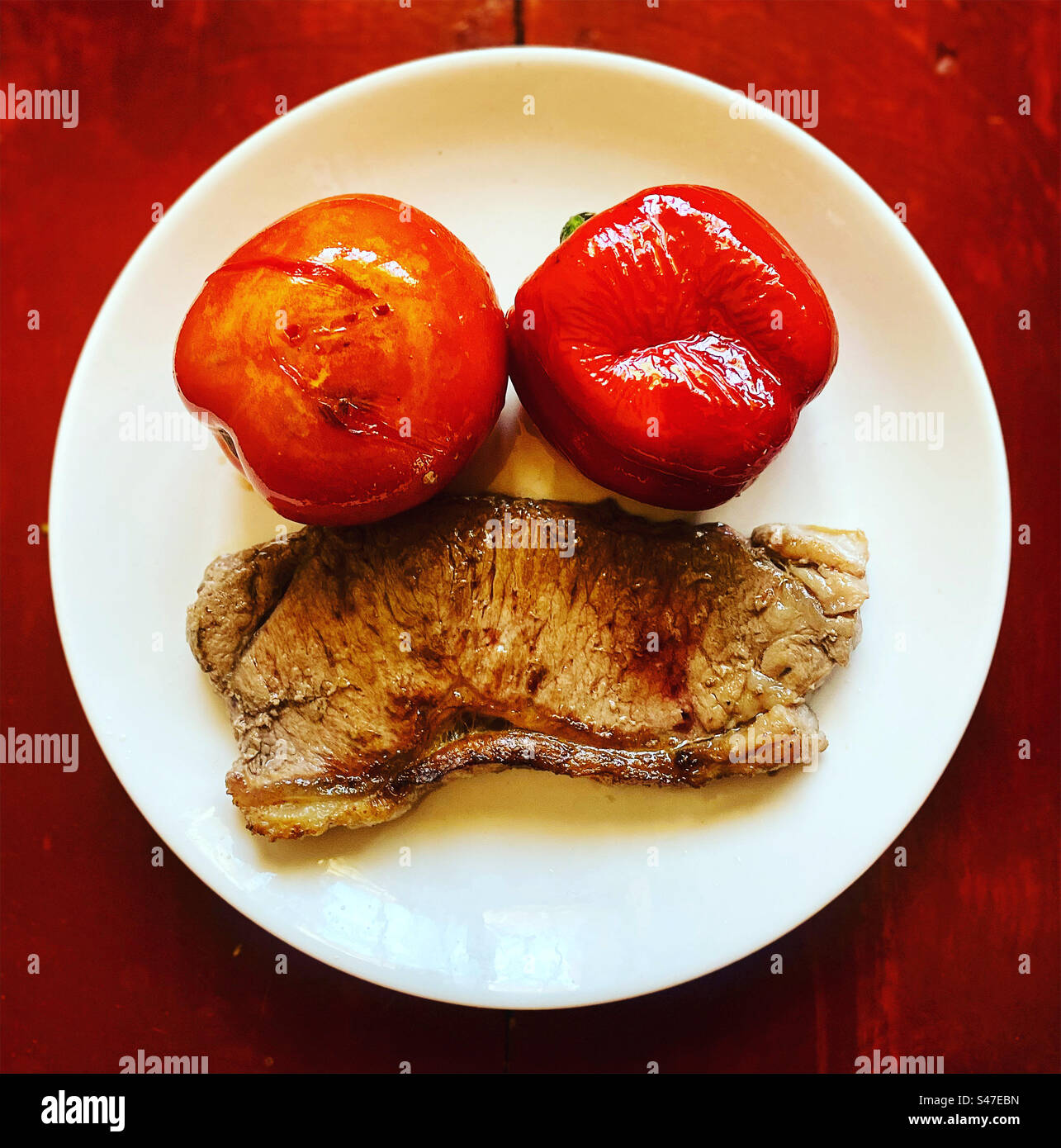 Ein gegrilltes New Yorker Steak, eine rote Tomate und eine rote Paprika auf einem Teller in Mexiko Stockfoto