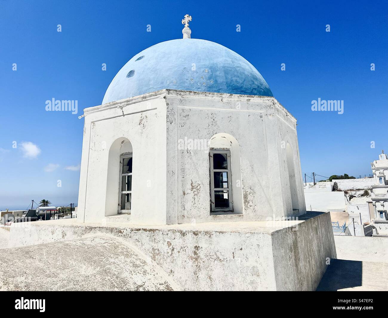 Heilige Kirche von Zoodochos Pigi, Kirche des lebensspendenden Frühlings, mit seiner blauen Kuppel neben einem Pfad in der Nähe des Zentrums von Megalochori Dorf auf Santorin. - Smartphone-aufgenommenes Stockfoto