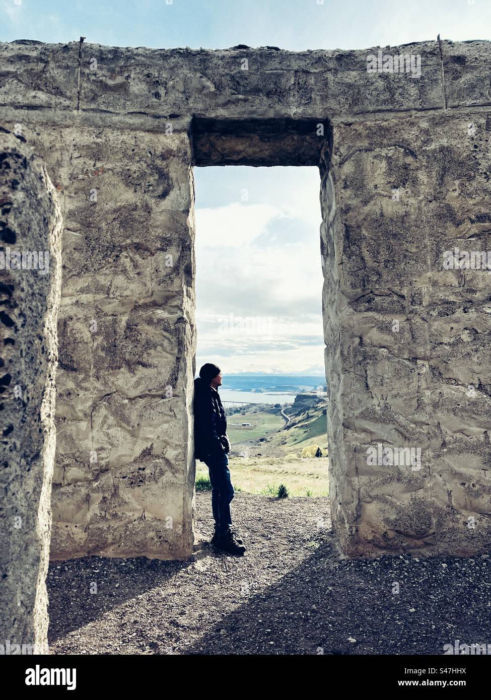 Mann im Bogen des Stonehenge Memorial in Maryhill, WA, mit Blick auf den Columbia River und den Mount Adams Stockfoto