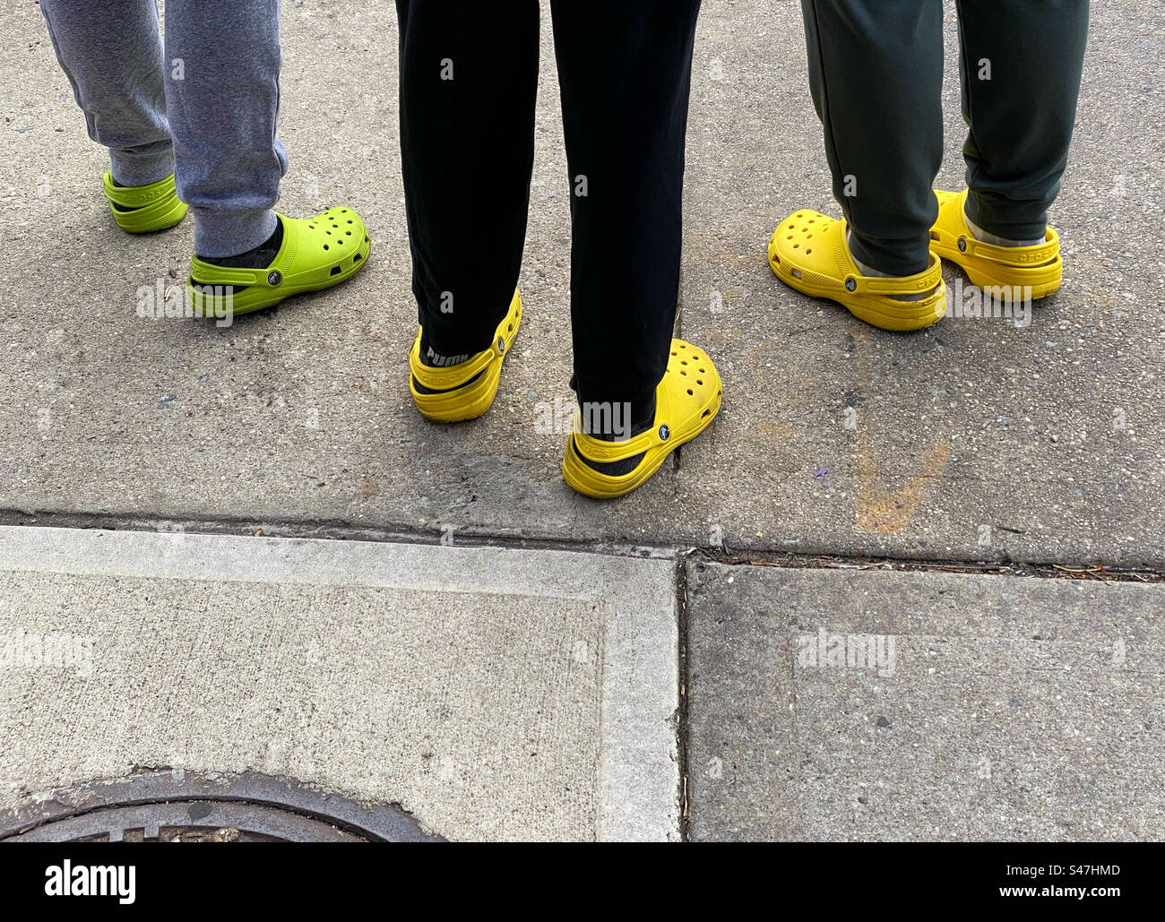 Drei Leute tragen bunte Krokodile, die auf einem Bürgersteig stehen Stockfoto