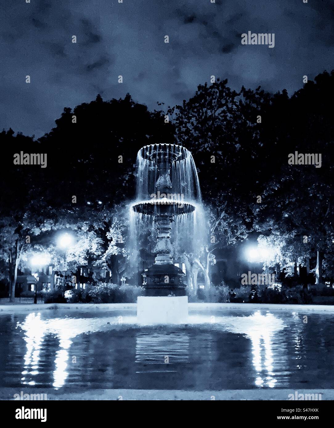 Der Wasserbrunnen auf dem Saint-Louis Square ist nachts beleuchtet. - Smartphone-aufgenommenes Stockfoto