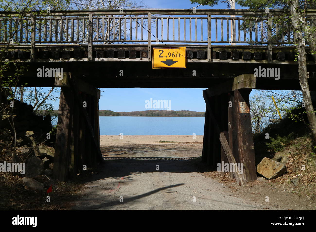 Brücke, die einen Strand umrahmt, Tunnel unter der Brücke zum See Stockfoto