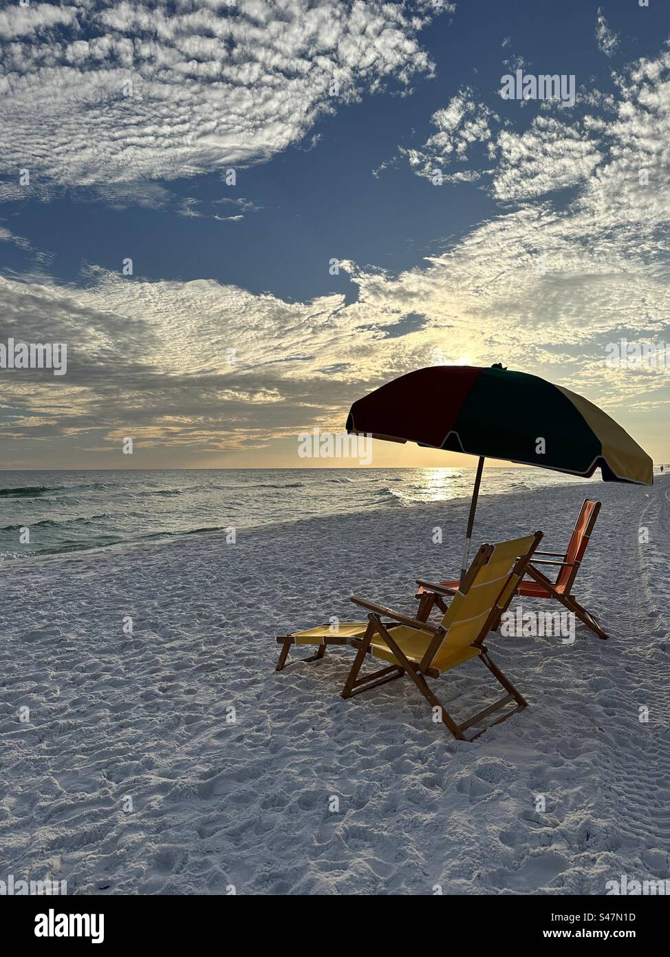 Emerald Coast Florida Strand Sonnenuntergang mit Stühlen und Sonnenschirm Stockfoto