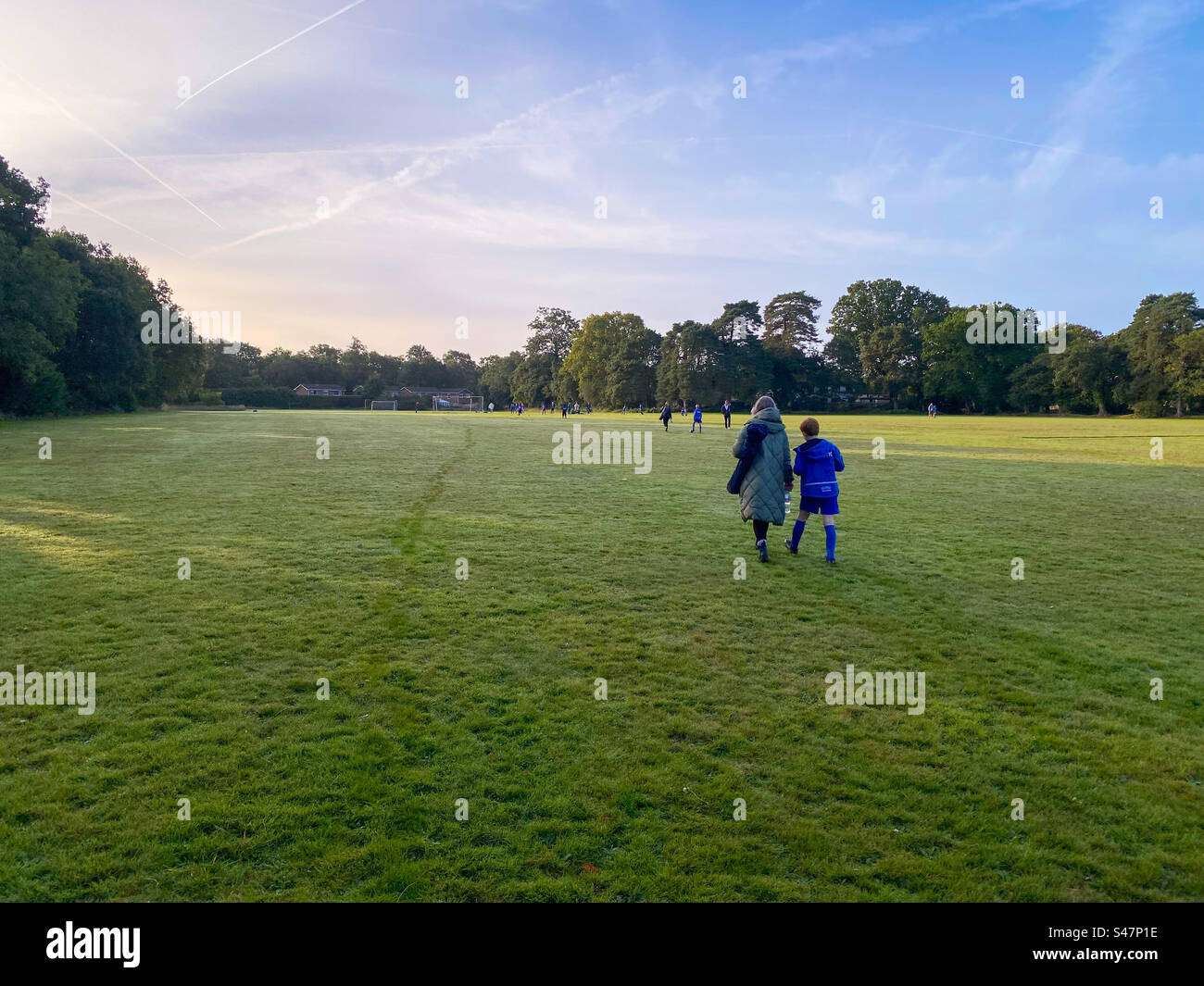 Leute, die früh am Morgen über ein Spielfeld laufen. Stockfoto