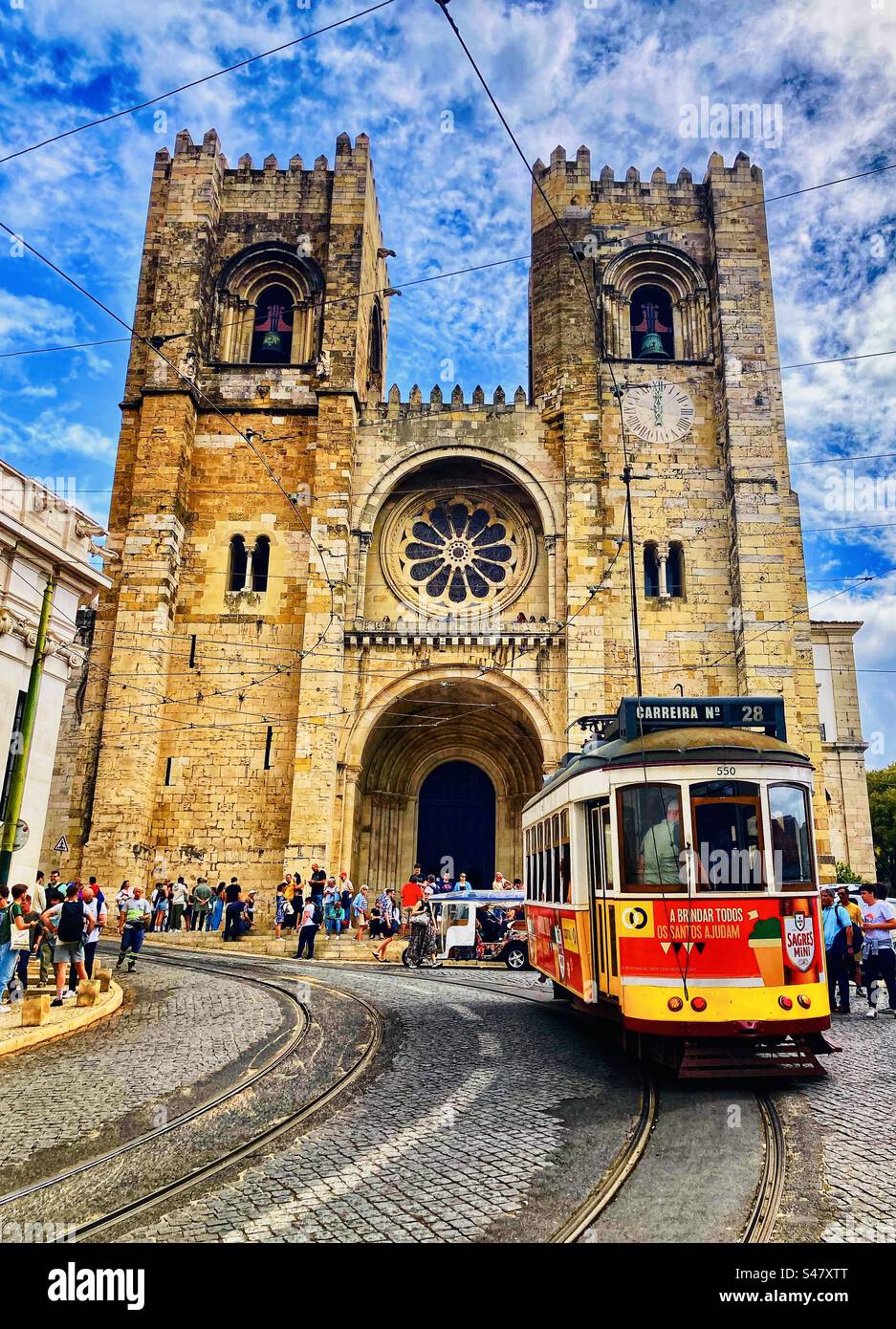 Straßenbahn Nr. 28, die an der Kathedrale in Lissabon, Portugal, vorbeifährt Stockfoto