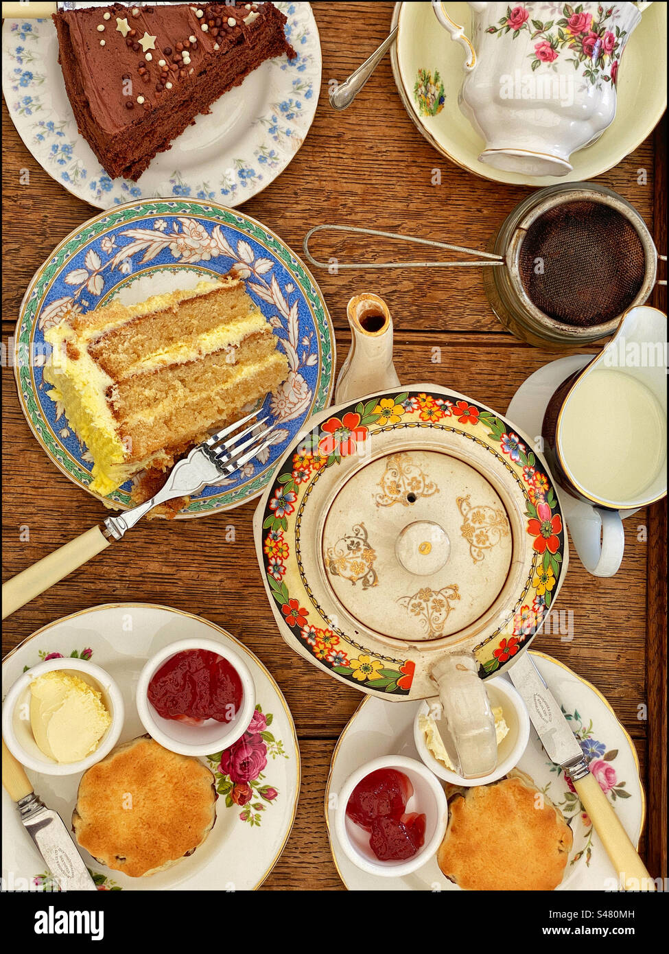 Blick von oben auf einen englischen Cream Tea mit Scones, Erdbeermarmelade, Clotted Cream und Schokoladenkuchen. Foto ©️ COLIN HOSKINS. Stockfoto