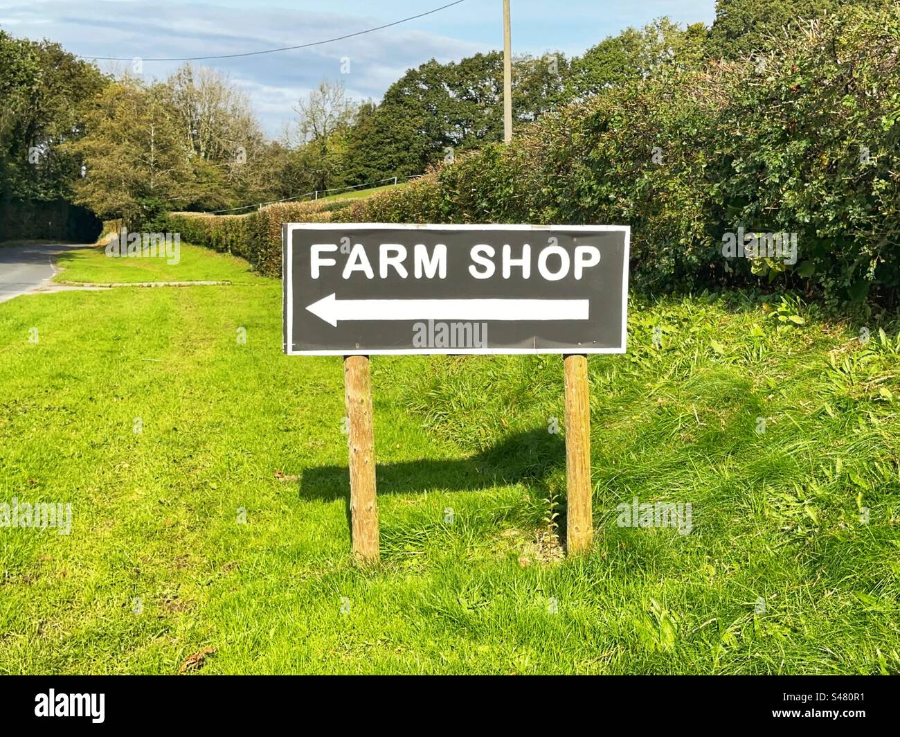 Schild für einen Bauernladen am Grasrand einer Landstraße. Keine Personen. Stockfoto