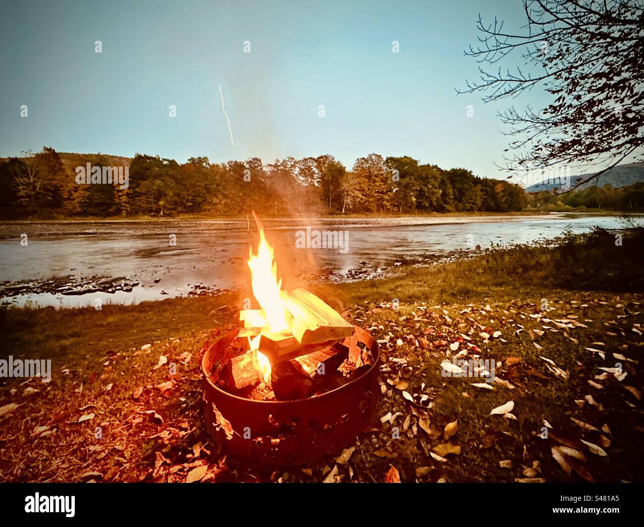 Feuerstelle am Fluss im Herbst Stockfoto