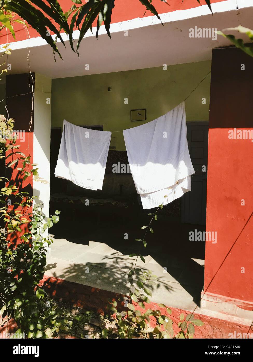 Zwei weiße Handtücher hängen an einer Wäscheleine und trocknen in der Sonne Stockfoto