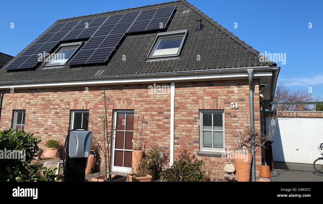 Haus mit Solarpaneelen und Ladestation für Elektrofahrzeuge - Smartphone-aufgenommenes Stockfoto