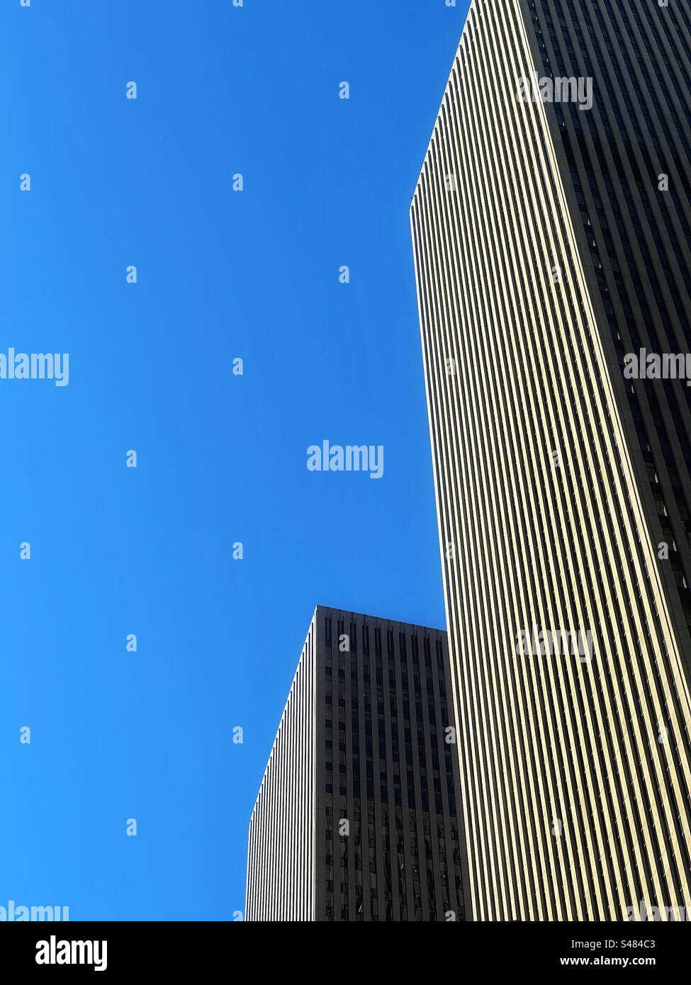 Wolkenkratzer in New York vor einem leuchtend blauen Himmel Stockfoto