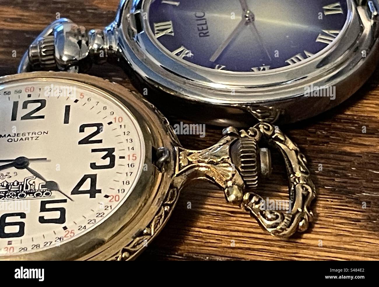 Zwei unterschiedlich gestaltete Taschenuhren zeigen die Zeiten im Stillleben. Stockfoto