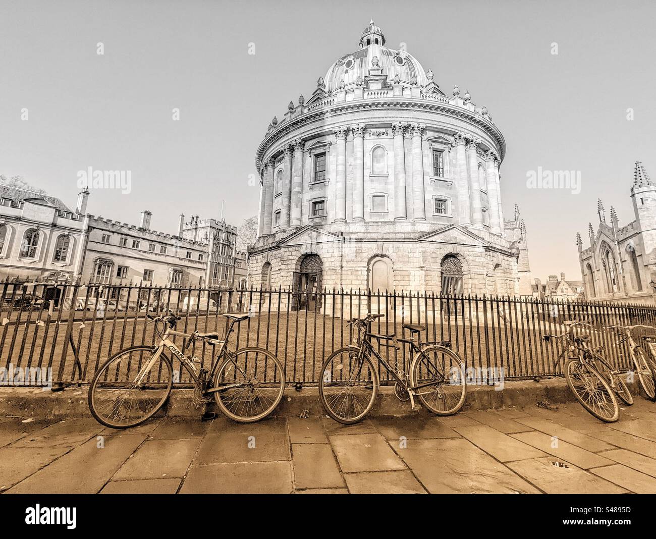 Die Radcliffe Camera Radcliffe Square Oxford Britain mit Fahrrädern, die am Geländer befestigt sind, und das Brasenose College in der Ferne Stockfoto