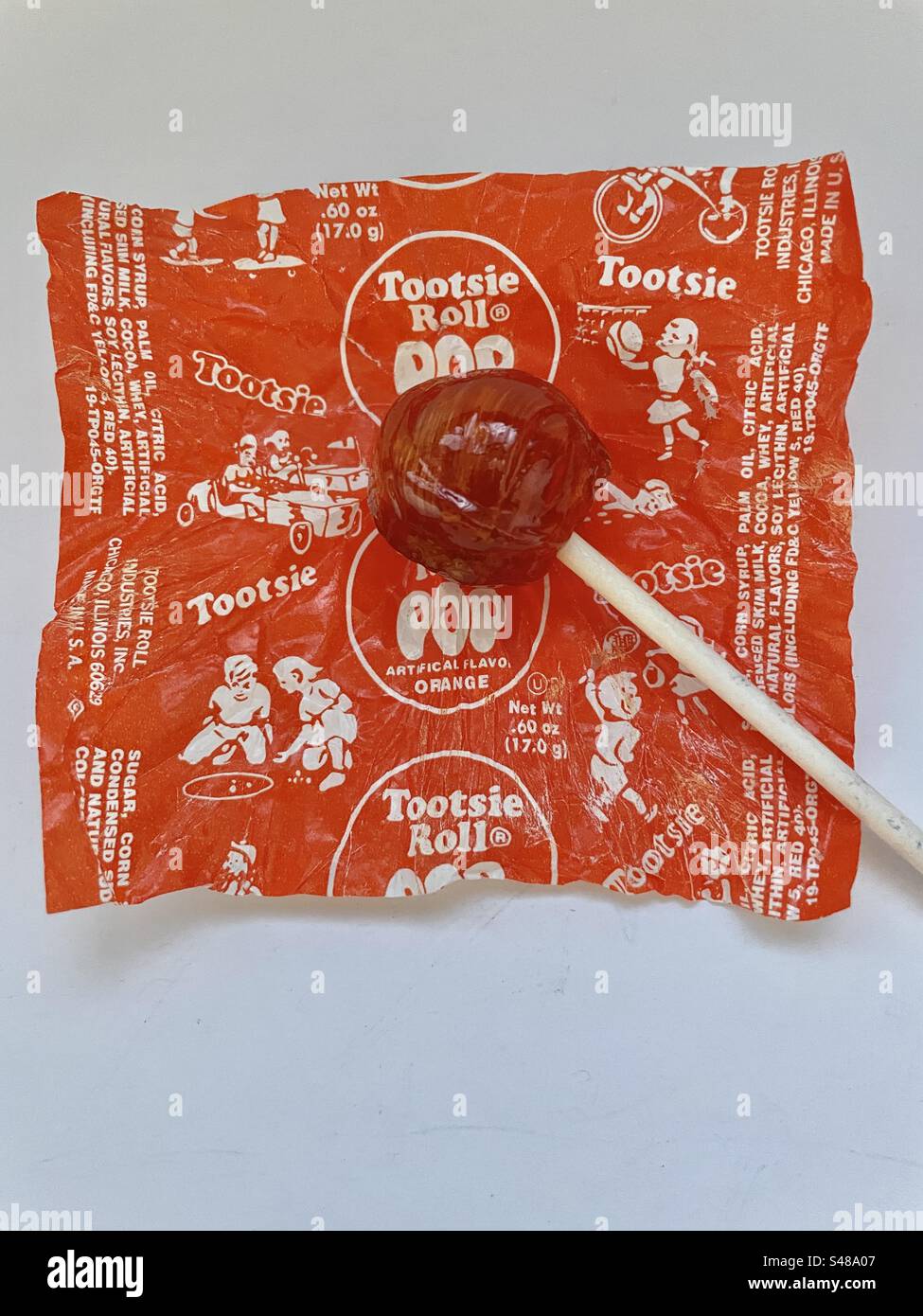 Tootsie Pop Sucker (Orangengeschmack) auf der Verpackung. - Smartphone-aufgenommenes Stockfoto