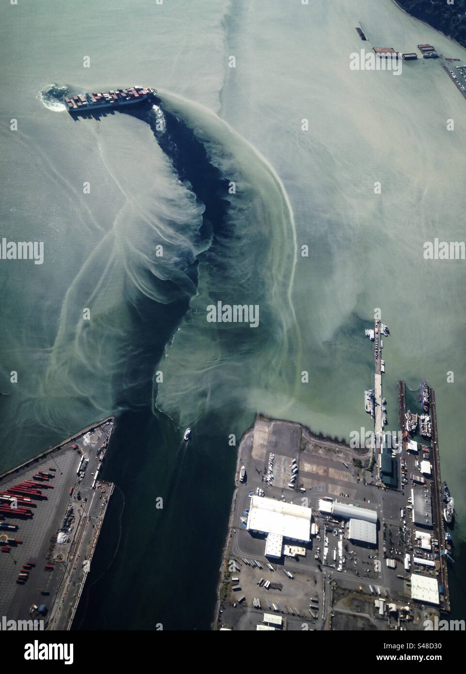 Das Schiff aus der Luft verlässt das schlammige Wasser und dockt im Hafen von Whittier, Alaska, wo der Großteil der Fracht in den Bundesstaat einfährt und mehrere Flusssysteme zusammenfließt - Smartphone-aufgenommenes Stockfoto