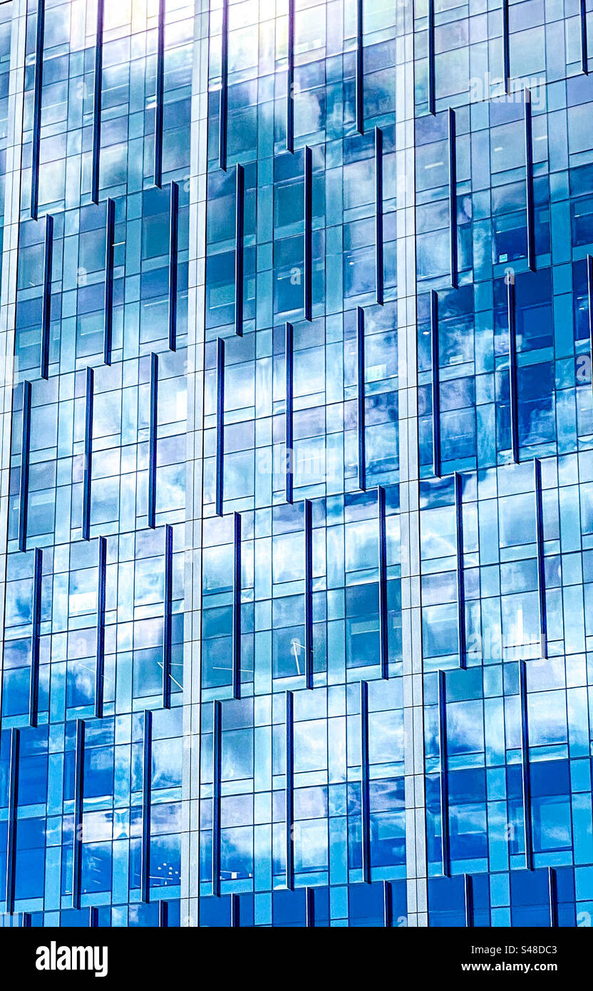 Blauer Himmel spiegelt sich im Glas eines Büroturms in der Innenstadt - Smartphone-aufgenommenes Stockfoto