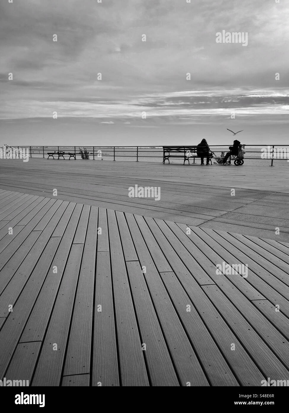Leute, die auf einer Promenade sitzen - Smartphone-aufgenommenes Stockfoto