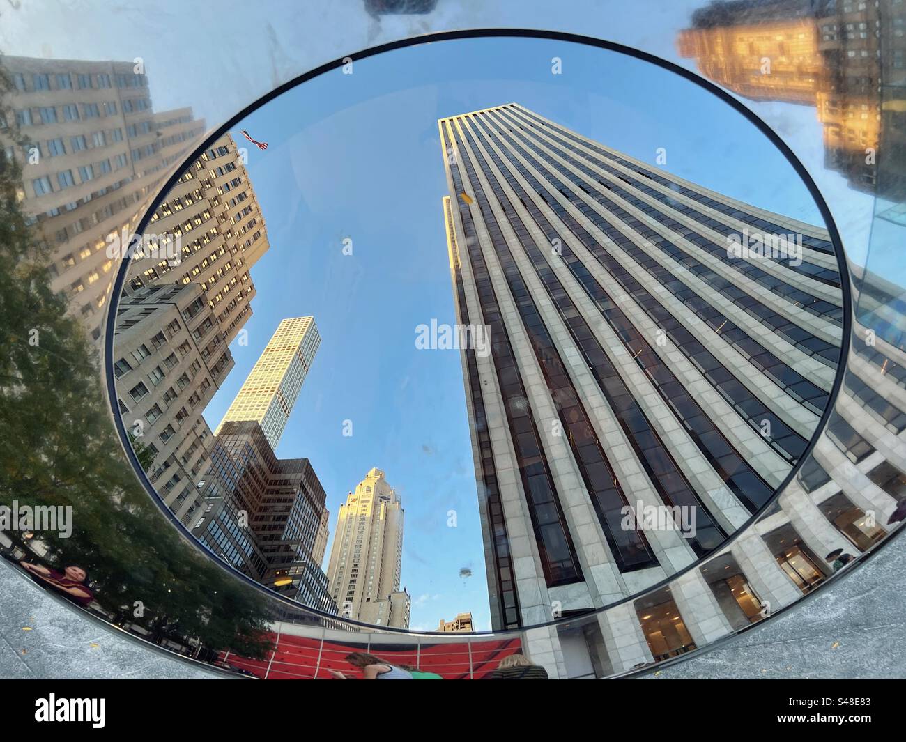 Reflexionen von Wolkenkratzern auf der 5th Avenue, New York in dekorativen Bänken am Apple Store - Smartphone-aufgenommenes Stockfoto