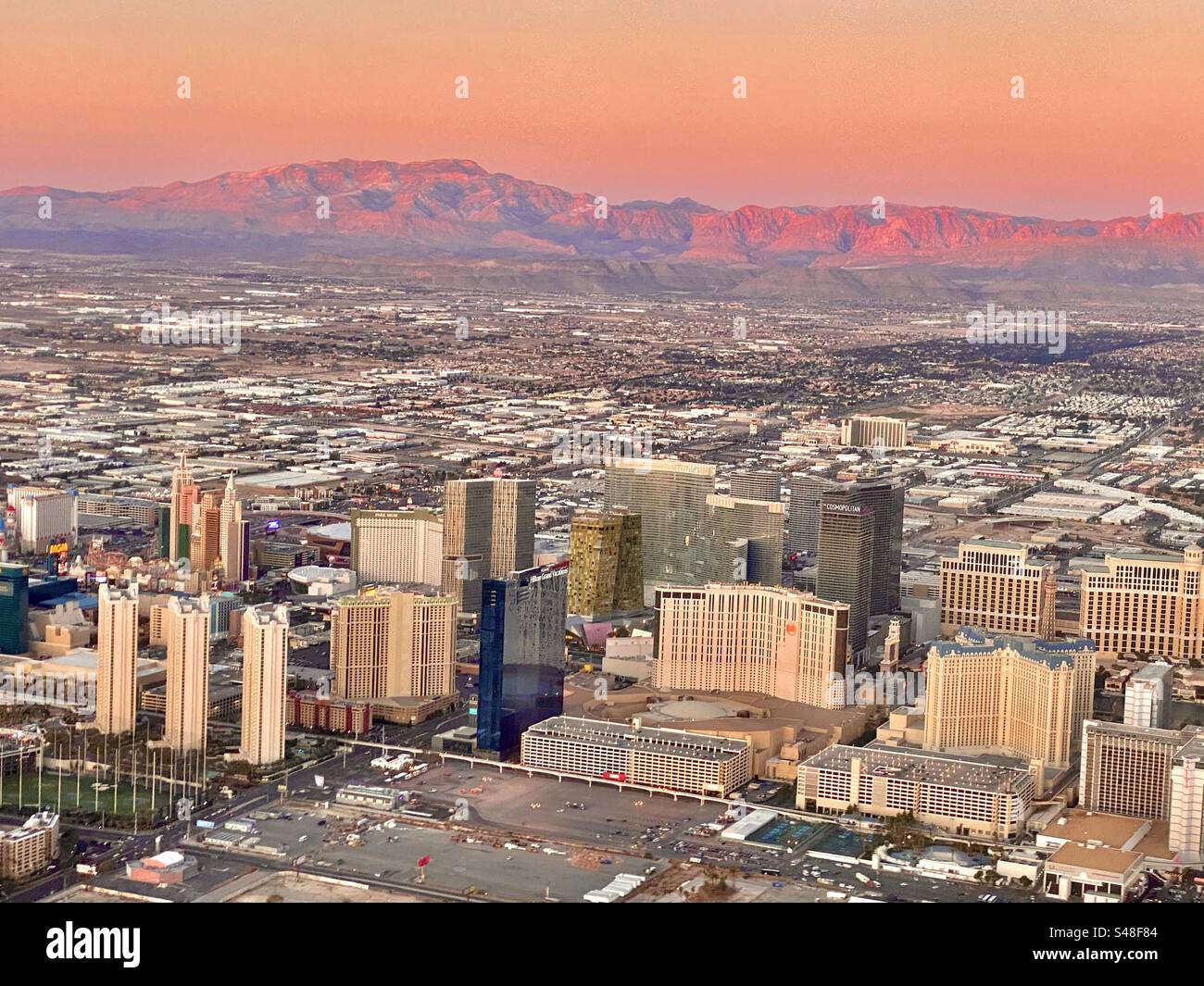 Blick auf Las Vegas bei einem wunderschönen Sonnenaufgang, der den Horizont und die Berge in leuchtenden Rosa- und Orangetönen bedeckt - Smartphone-aufgenommenes Stockfoto