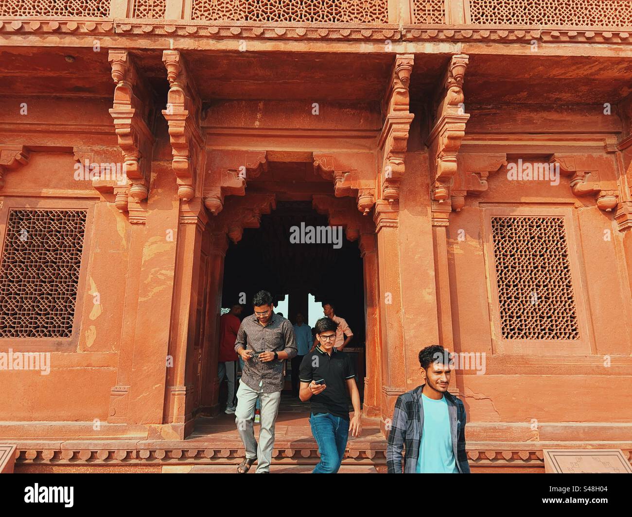 Indische Touristen erkunden die Paläste Akbar und Jodha Bai’a in Fatehpur Sikri, einem historischen Weltkulturerbe - Smartphone-aufgenommenes Stockfoto