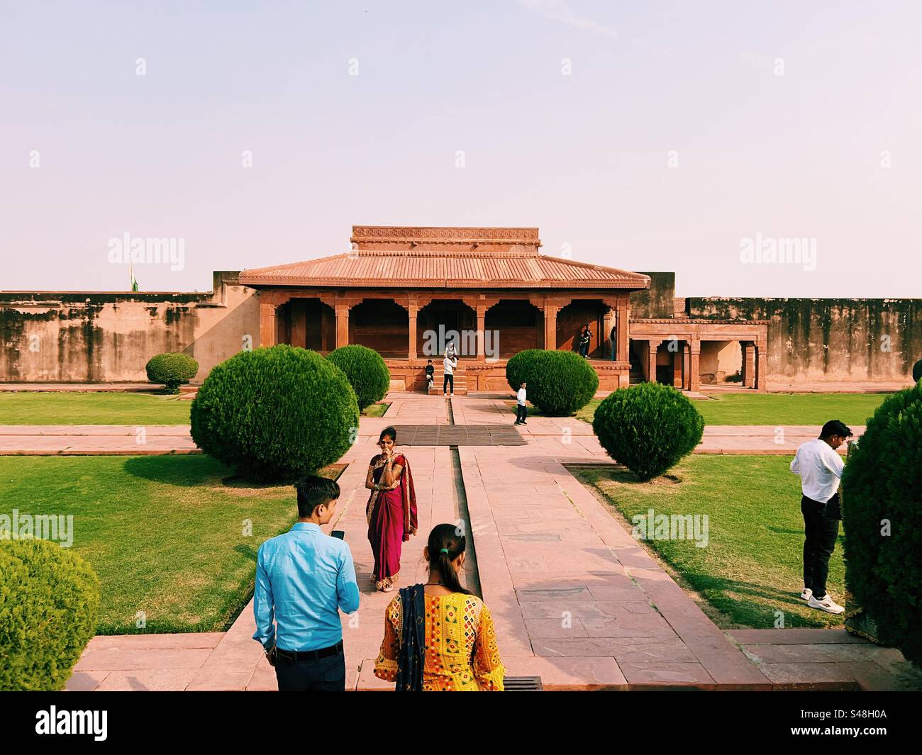 Indische Touristen in hellen Kleidern genießen die historischen Stätten in Fatehpur Sikri in der Nähe von Agra Stockfoto