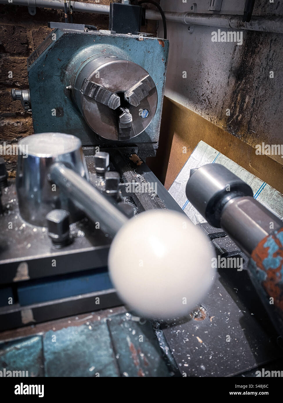 Eine mechanische Drehmaschine in einer kleinen Werkstatt - Smartphone-aufgenommenes Stockfoto
