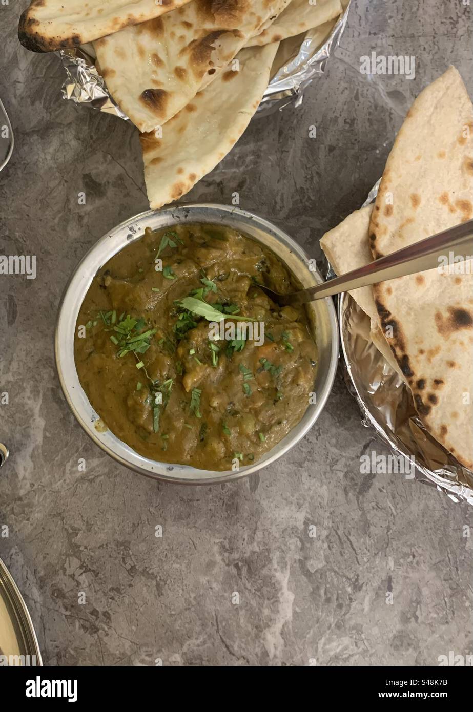 Gemischtes Gemüse-Curry serviert mit Butter Naan und Roti in einem vegetarischen indischen Restaurant - Smartphone-aufgenommenes Stockfoto