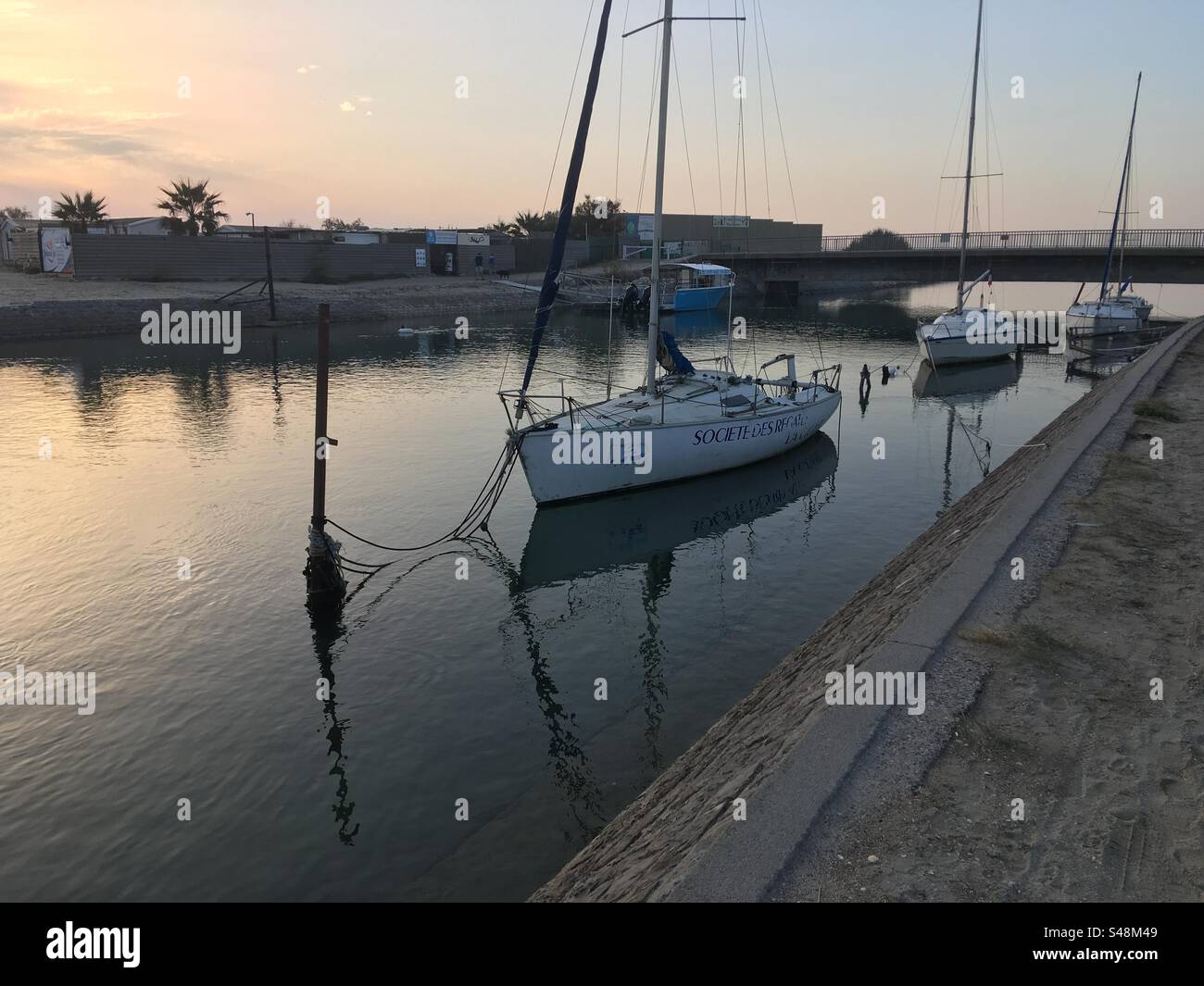 Landschaftsaufnahme eines Kanals mit Segelbooten bei Sonnenuntergang Stockfoto