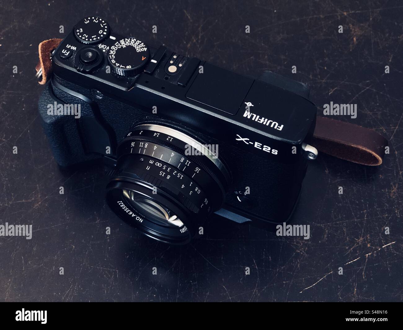 3/4 Dreiviertelansicht einer spiegellosen Fujifilm X-E2s-Digitalkamera mit Entfernungsmesser auf einem schwarzen Tisch Stockfoto