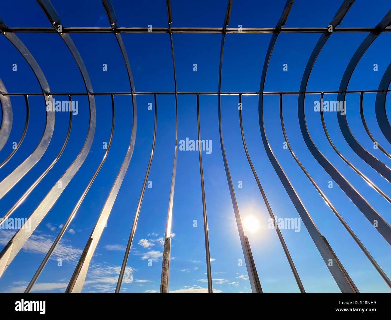 Zusammenfassung der Sicherheitsbarriere auf der Aussichtsplattform des Empire State Building Building Building gegen die Sonne und einen leuchtend blauen Himmel Stockfoto