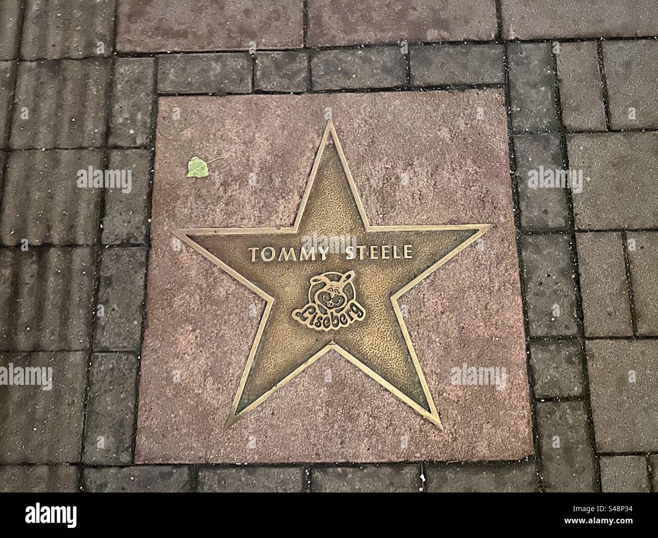 Ein Star für das ehemalige britische Teenager-Idol Tommy Steele auf dem Bürgersteig in Liseberg, Göteborg, Schweden. - Smartphone-aufgenommenes Stockfoto