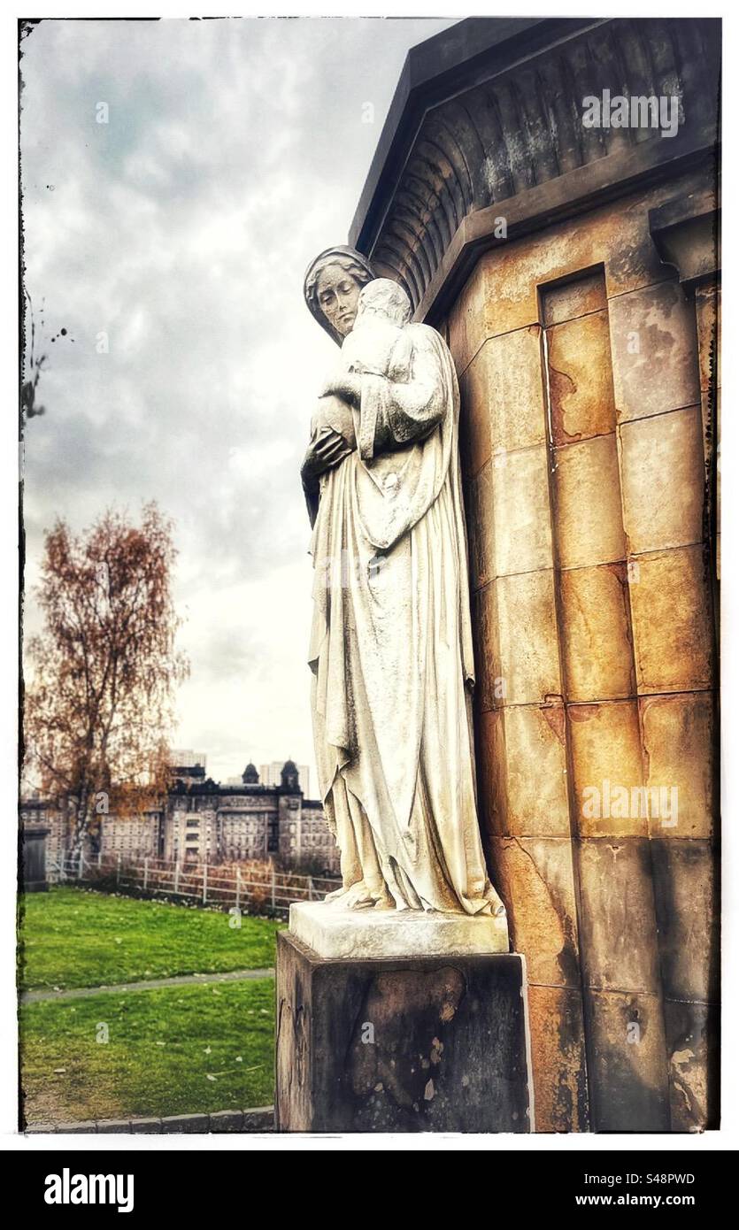 Statue einer Dame, die ein Baby auf einem Friedhof hält. Stockfoto