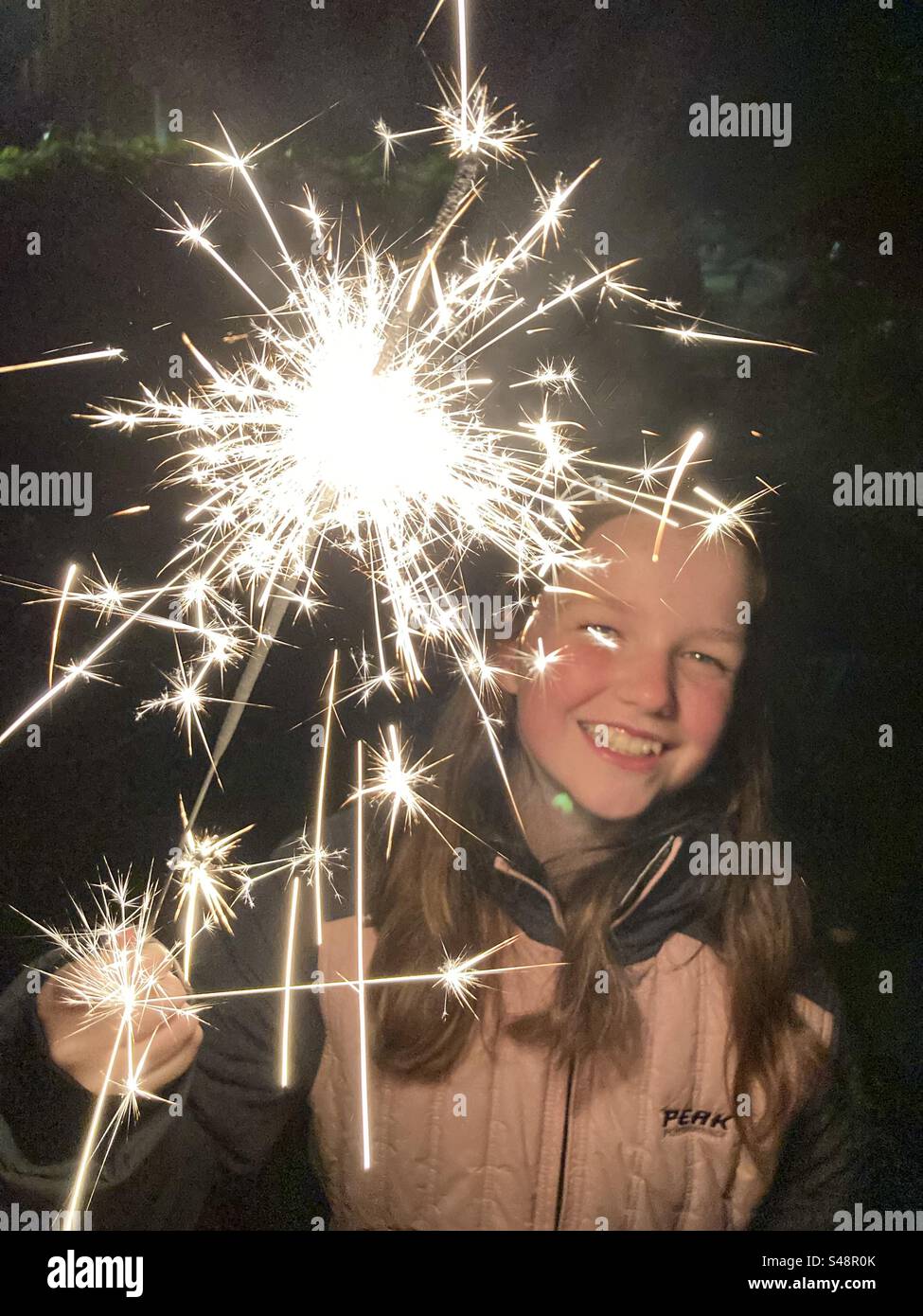 Mädchen, 11 Jahre alt, mit einem Wunderkerzen am Lagerfeuer. Uk Stockfoto